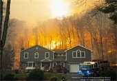 House with wildfire burning in background.