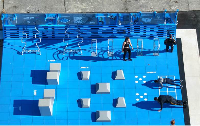 A group of exercisers doing pushups and other exercises on outdoor workout court.