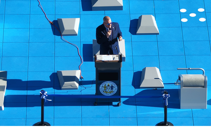 Mayor Gregory Wolfe shown from above standing at podium for opening of fitness park